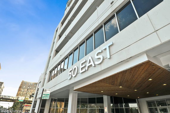 Front view of a modern multi-story building with the number 50 prominently displayed.