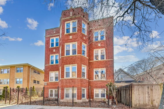 Front view of a multi-story brick building with multiple windows.