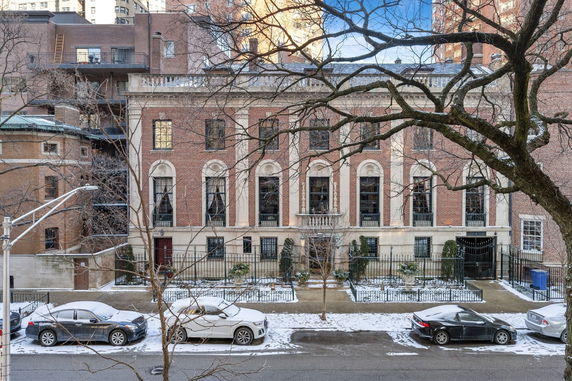 Front view of a multi-story brick building with large windows and decorative stonework.