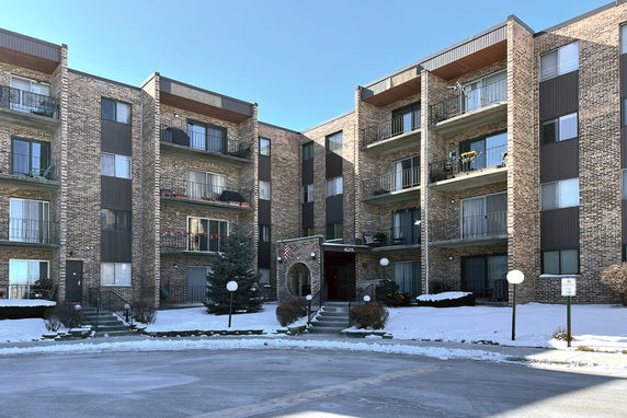 Front view of a multi-story apartment building with balconies.
