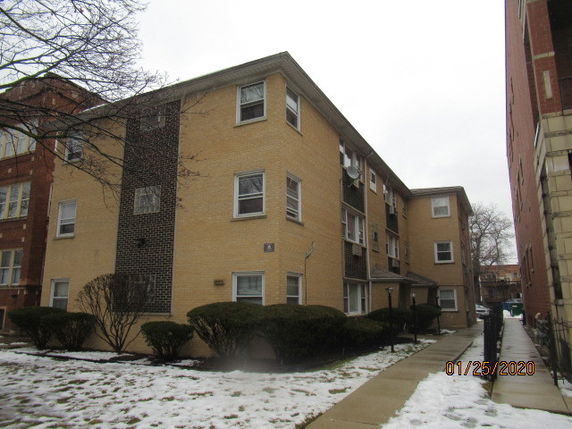 Front view of a three-story apartment building with brick exterior.