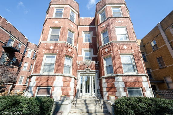 Front view of a multi-story brick building with a central entrance.