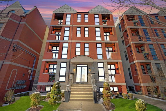 Front view of a multi-story brick building with symmetrical windows and a central entrance.