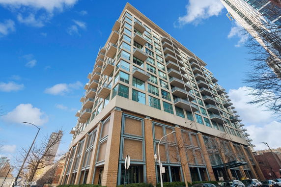 Front view of a modern multi-story apartment building with balconies.