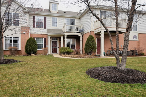 Front view of a two-story residential building with brick and siding exterior.