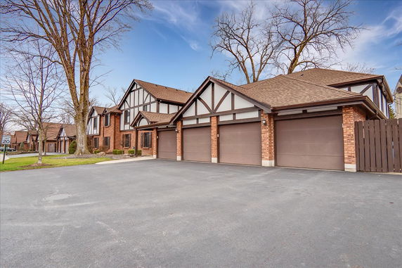 Front view of a multi-story house with three garages.