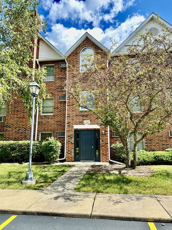 Front view of a multi-story brick building with a central entrance.