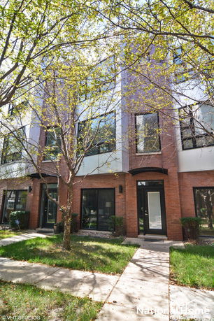 Front view of a multi-story building with brick facade and large windows.