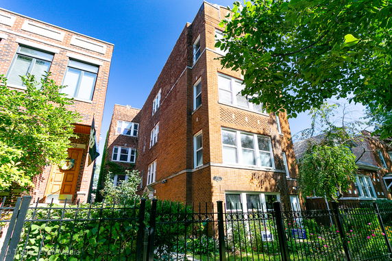 Front view of a multi-story brick building with multiple windows.