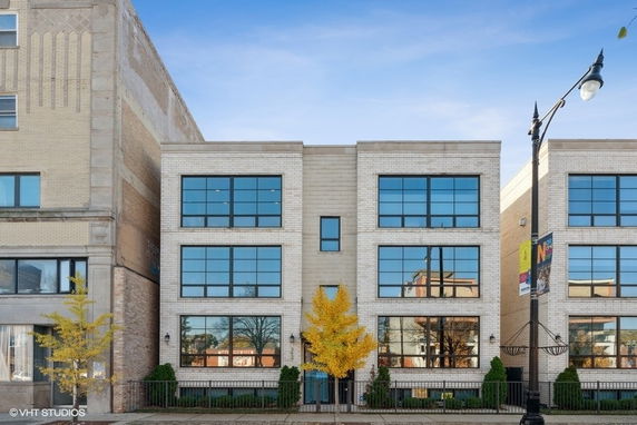 Front view of a modern three-story building with large windows.