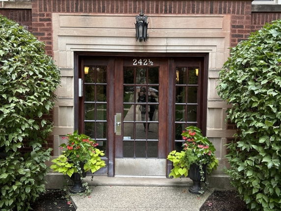 Front view of a building entrance with glass-paneled doors and brick facade.