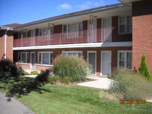 Front view of a two-story brick building with balconies.
