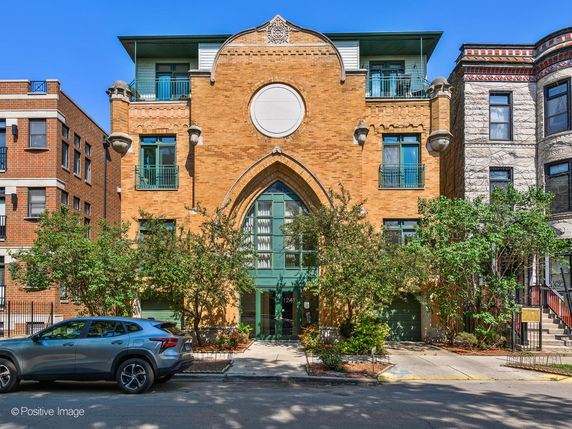 Front view of a multi-story brick building with unique architectural elements and balconies.