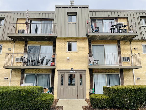 Front view of a multi-story apartment building with balconies.