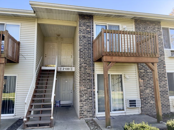 Front view of a two-story building with external staircases and balconies.