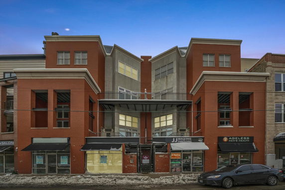 Front view of a commercial building with multiple storefronts and modern architectural design.