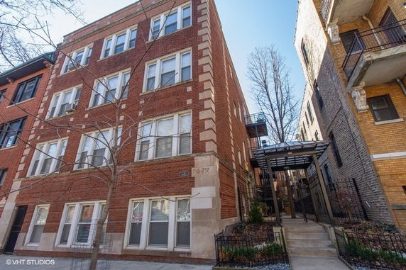 Front view of a multi-story brick apartment building.