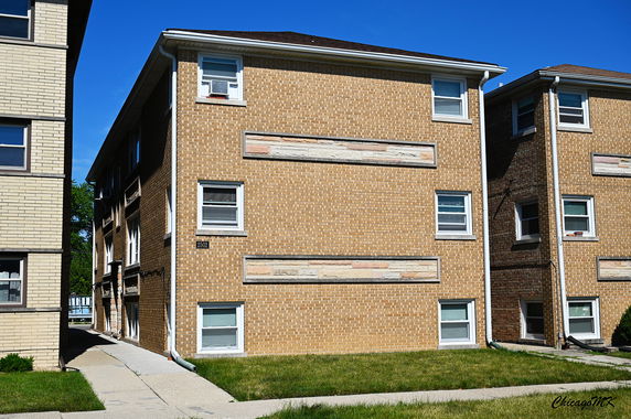 Front view of a three-story brick apartment building.