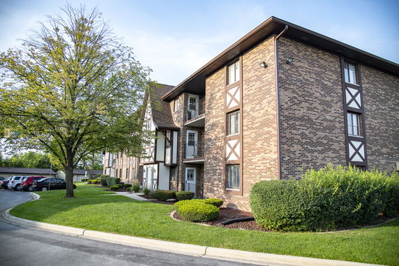 Front view of a multi-story apartment building with a brick facade and balconies.