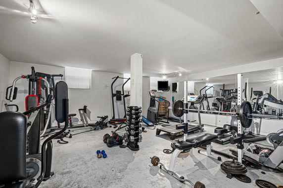 Home gym area with various exercise equipment and weights.