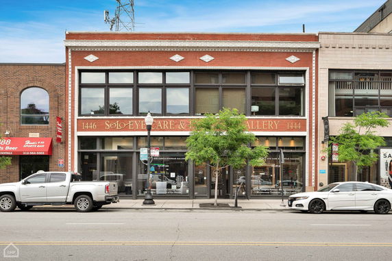Front view of a two-story commercial building with large windows and signage for an eyecare and eyewear gallery.