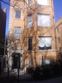Front view of a multi-story brick building with large windows.