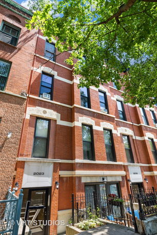 Front view of a multi-story brick building with large windows and decorative stone accents.
