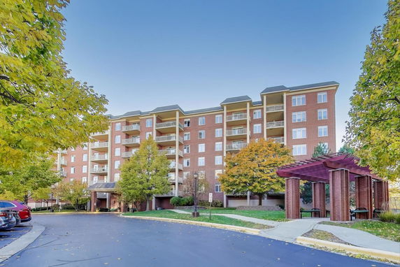 Front view of a multi-story brick residential building with balconies.