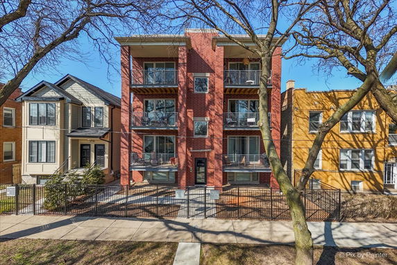 Front view of a multi-story brick building with balconies.
