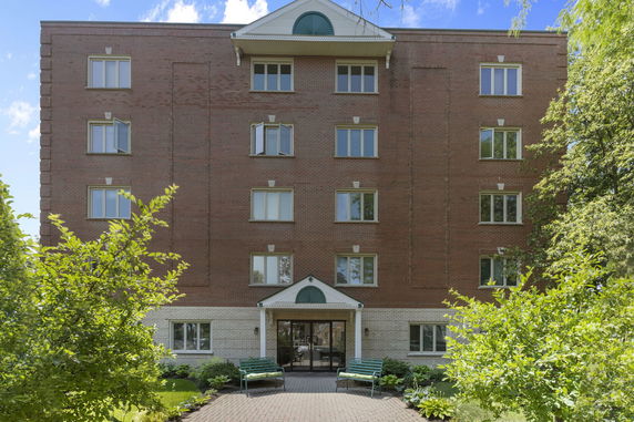 Front view of a multi-story brick building with multiple windows.