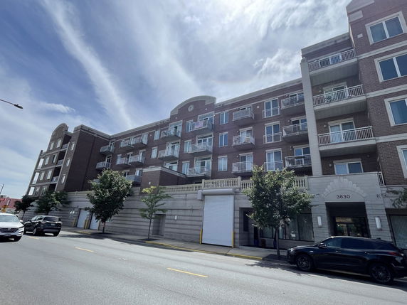 Front view of a multi-story apartment building with balconies.
