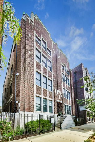 Front view of a multi-story brick building with multiple windows.