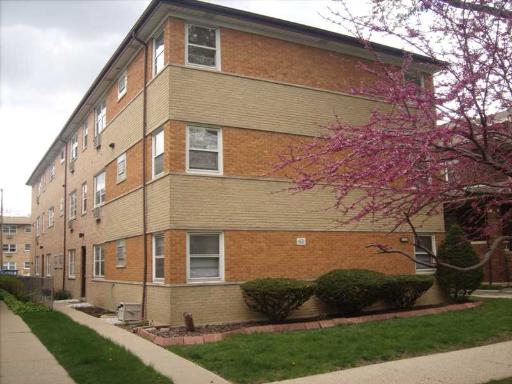 Front view of a three-story apartment building with brick exterior.
