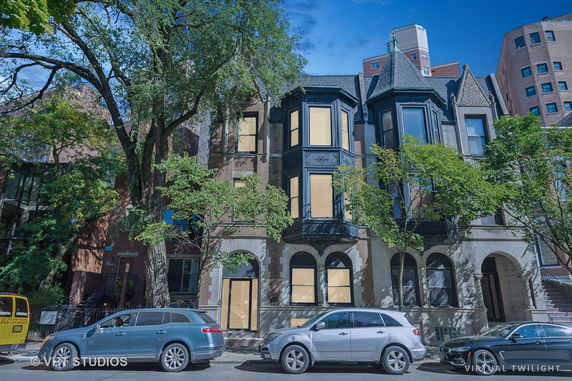 Front view of a multi-story building with bay windows and brick facade.