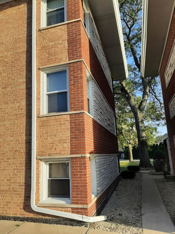 Side view of a brick apartment building with multiple windows.