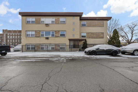 Front view of a three-story apartment building with a flat roof.