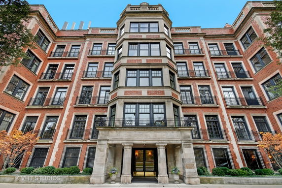 Front view of a multi-story brick building with large windows and balconies.