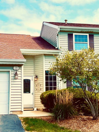 Front view of a two-story house with brick facade and attached garage.