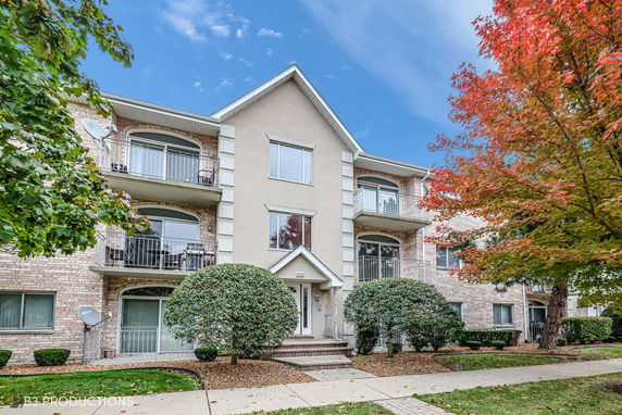 Front view of a three-story residential building with balconies.