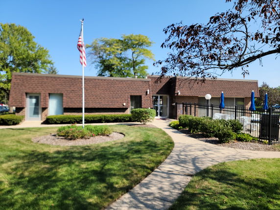 Front view of a single-story brick building with a flagpole in front.
