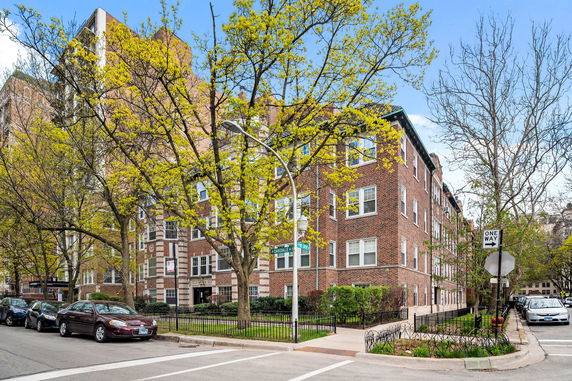 Corner view of a multi-story brick apartment building.