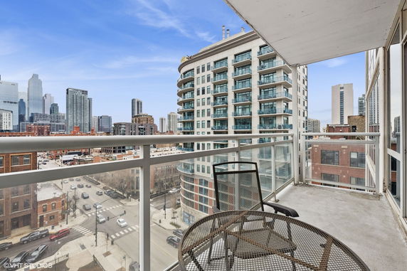 View from a balcony overlooking a cityscape with tall buildings.
