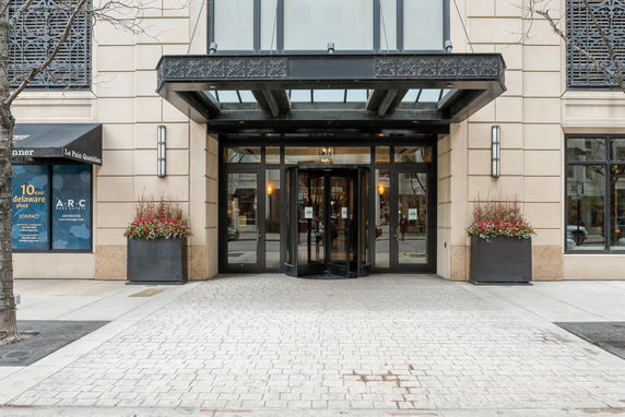 Front elevation of a building with a revolving door entrance and large planters.
