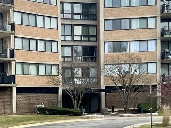 Front view of a multi-story building with large windows and balconies.