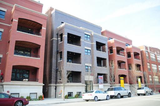 Front view of a multi-story apartment building with balconies.