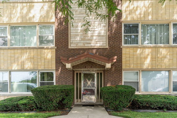 Front view of a multi-story brick building with a central entrance.