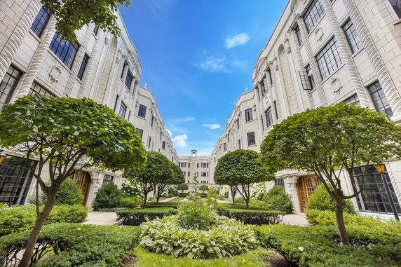 Front view of a multi-story building with ornamental landscaping.