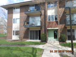 Front view of a multi-story apartment building with balconies.