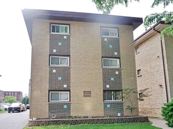 Front view of a three-story apartment building with a brick exterior.