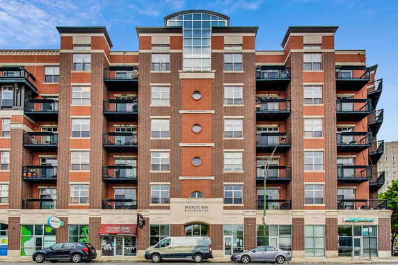 Front view of a multi-story residential building with brick facade.